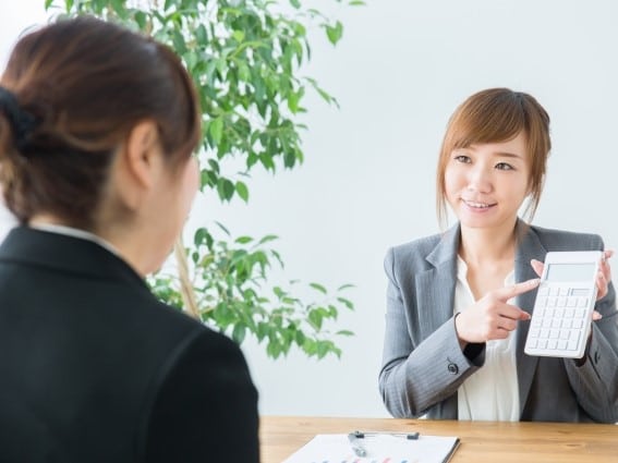 電卓をもって説明する女性