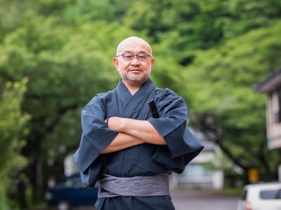 腕組をして立つ浴衣姿の中高年男性