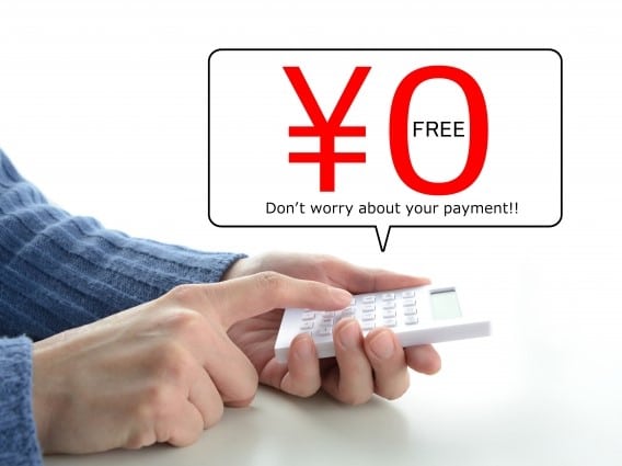 電卓をはじく男性の手と0円の文字
