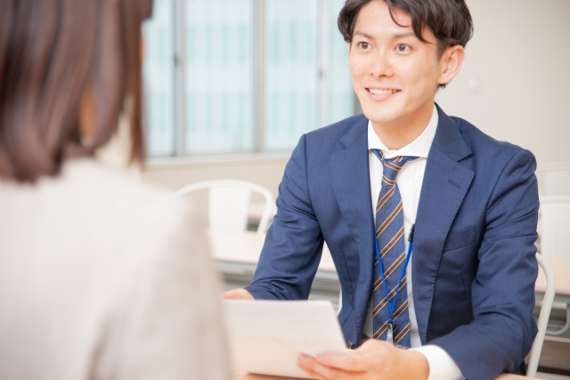 スーツを着た男性と話す女性