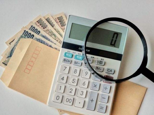 電卓、お金、虫眼鏡