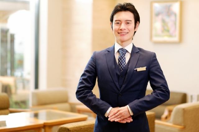 スーツでお客様を迎える男性