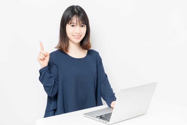 パソコンを操作する青い服の女性