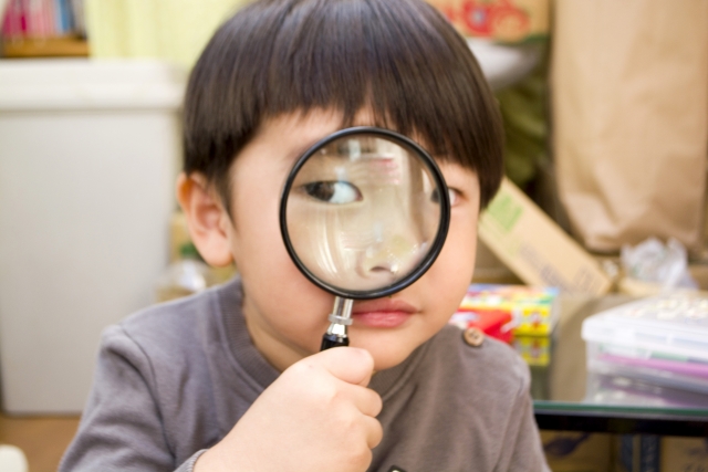 虫眼鏡を覗く子ども